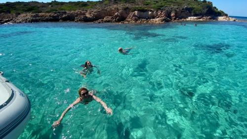 Family on a boat vacation takes a swim in the clear sea of Corsica
