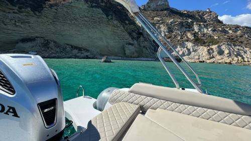 Barco inflable con toldo en las aguas azules de Cagliari