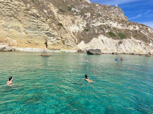 Escursionisti nuotano di fronte ai faraglioni del Golfo di Cagliari