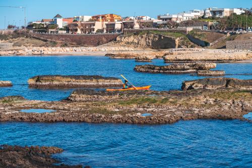 Escursionista in kayak nella costa frastagliata di Porto Torres alle spiagge delle Acque Dolci