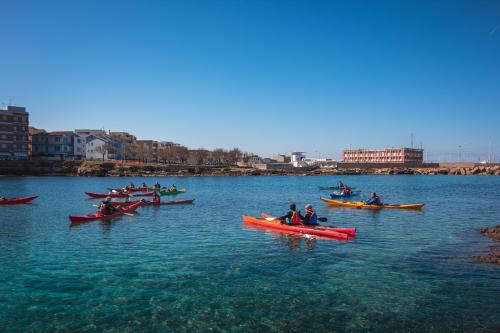 Group kayaking in the sea in front of Scogliolungo beach