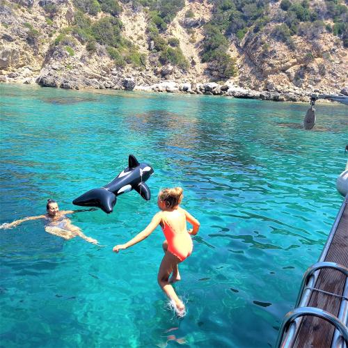 <p>Kindertauchen von einem Boot im türkisfarbenen Meer der Alghero-Region</p><p><br></p>