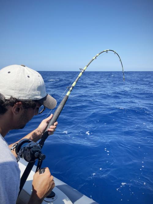 Escursionista durante pesca a bordo di un gommone con pescatore esperto 