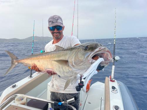 Fisherman on board an inflatable boat while fishing in south-west Sardinia