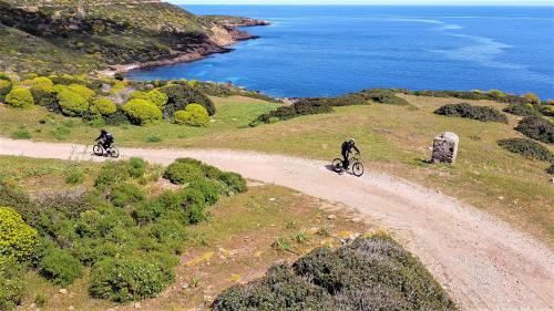 Excursionistas en bicicleta eléctrica con vistas al mar en Asinara