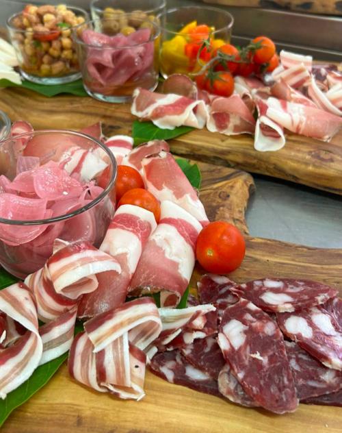 Tabla de cortar con fiambres, tomates cherry, cebollas, garbanzos, pimientos y aceitunas