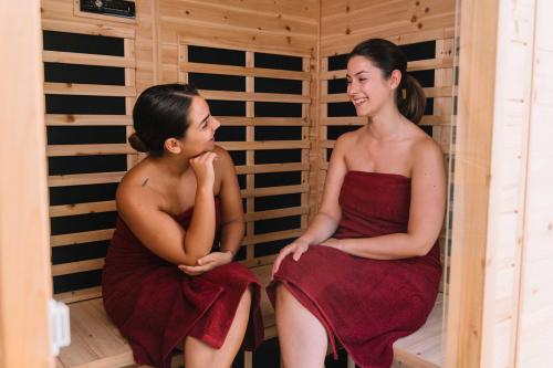 Two girls laugh inside the sauna