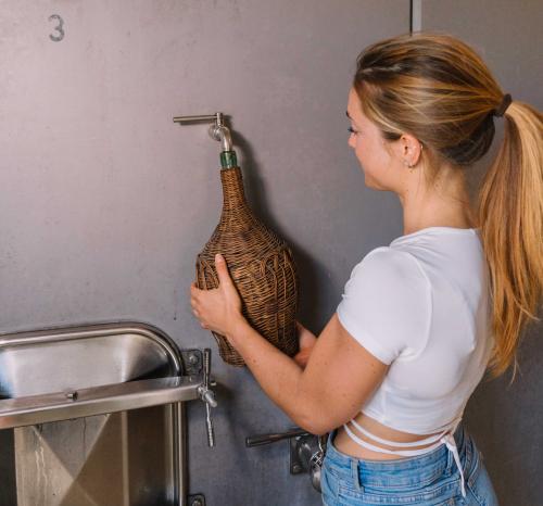 A girl fills the a container with wine