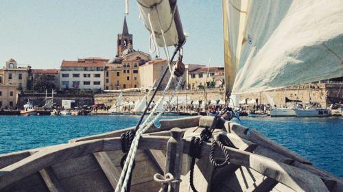 The boat sails toward the port of Alghero