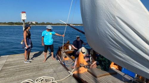 Captain brings passengers aboard the vintage boat in the Gulf of Alghero