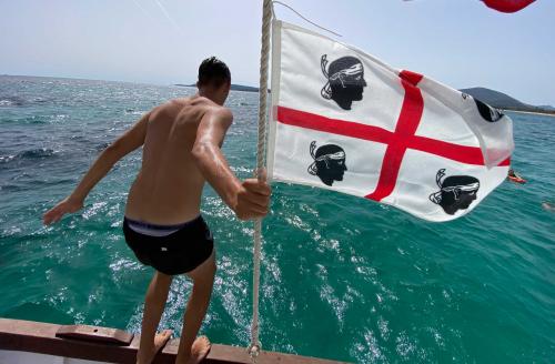 Wanderer taucht vom Boot aus in den Golf von Alghero