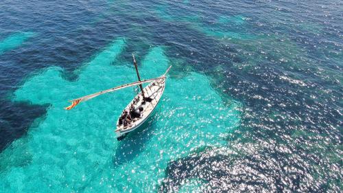 Historic sailboat in the blue water of the Gulf of Alghero