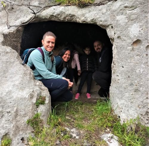 Domus de janas e turisti durante trekking con asini a Cargeghe