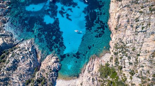 Vista superior de un barco anclado frente a una isla del archipiélago de La Maddalena