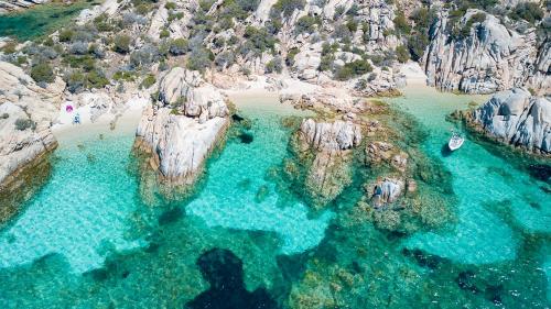 Die felsige Küste einer Insel des La Maddalena-Archipels mit klarem, blauem Wasser
