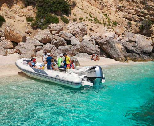 Schlauchboot landet auf einem Strand mit dem blauen Wasser des Golfs von Orosei