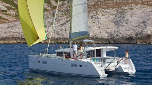 Catamaran sailing in the crystal-clear waters of Molara