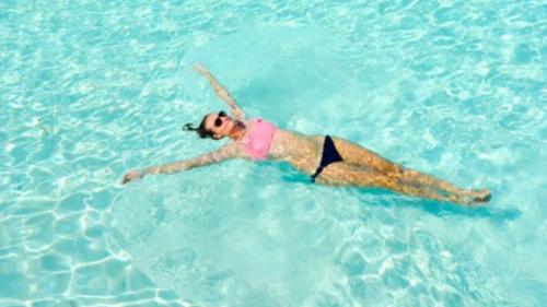 Mädchen badet im blauen Wasser des Golfs von Marinella