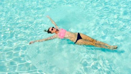 Ragazza fa il bagno nell'acqua azzurra del Golfo di Marinella