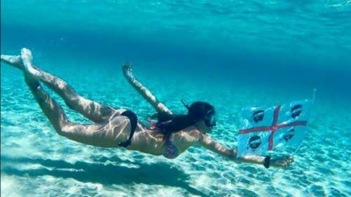 Ragazza fa il bagno con la bandiera della Sardegna