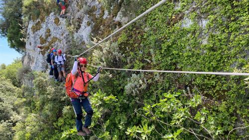 Escursionisti attraversano il ponte tibetano