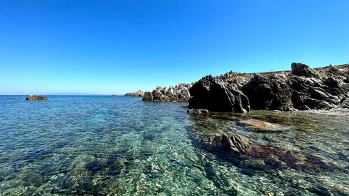 Kristallklares Meer und dunkle Felsen auf der Insel Mal di Ventre