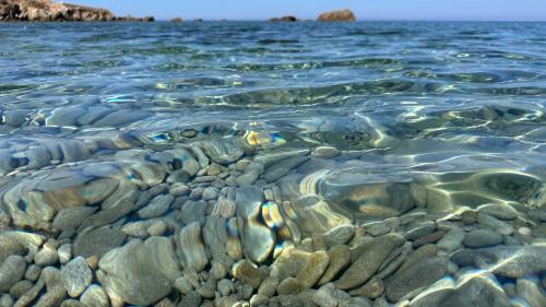 Crystal clear water and pebbles off the coast of Mal di Ventre
