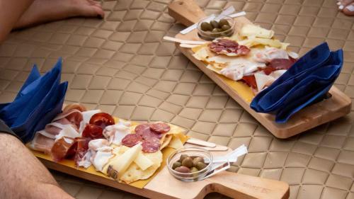 Assiettes de charcuterie et de fromages servies lors d'un apéritif sur un bateau pneumatique au coucher du soleil à Porto Flavia