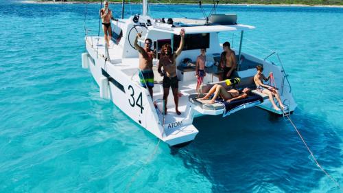 Los excursionistas a bordo del catamarán saludan