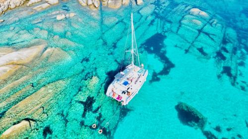 Catamaran stops in the clear waters of Cala dei Graniti in Asinara