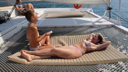 Young girls relax at the bow of the catamaran