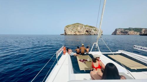 El catamarán navega hacia Capo Caccia durante una excursión al atardecer