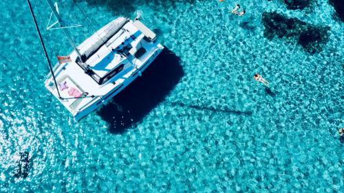 El catamarán se detiene mientras los excursionistas se bañan en las aguas azules de las piscinas Fornelli