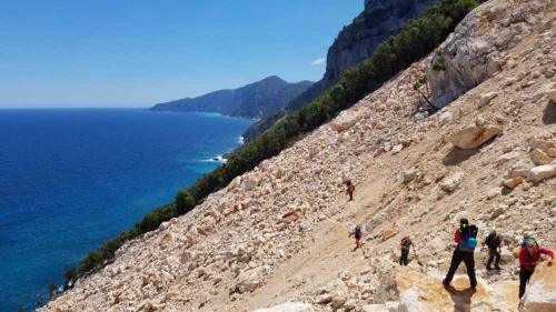 Wanderer gehen auf einem abschüssigen Pfad in der Selvaggio Blu