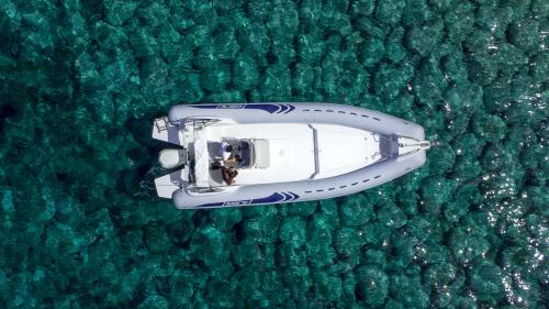 Gommone naviga nell'acqua azzurra del sud ovest della Sardegna