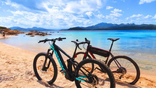 Deux vélos électriques sur une plage de la Costa Smeralda