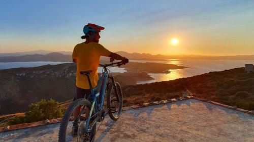 Un randonneur s'arrête sur le Mont Moro face à la côte au coucher du soleil