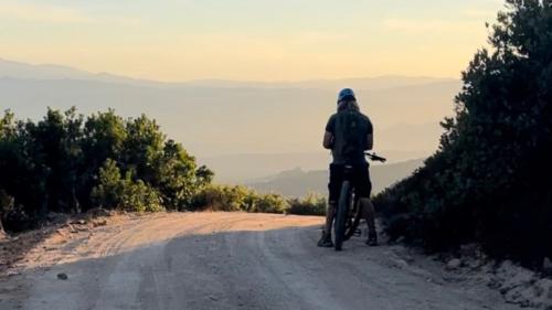 Un senderista se detiene durante una excursión en e-bike al Monte Moro al atardecer