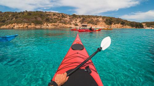 Wanderer hält im blauen Meer in der Nähe der Küste von Asinara