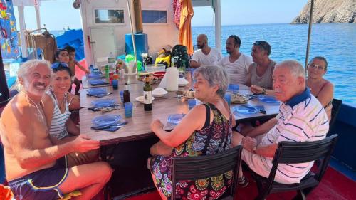 Partecipanti pranzano nella baia di Masua con vista sul faraglione di Pan di Zucchero