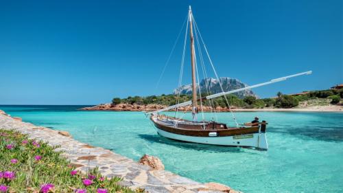 Bateau dans l'eau de mer cristalline de l'aire marine protégée de Tavolara