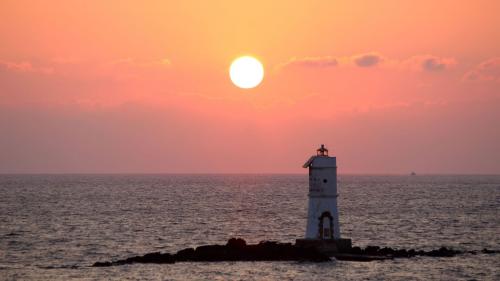 View of the Mnagiabarche lighthouse at sunset