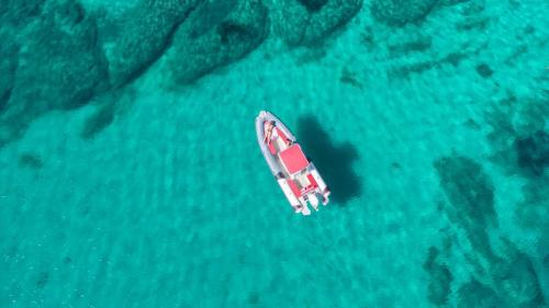 Inflatable boat sails in the emerald water of the Gulf of Cagliari