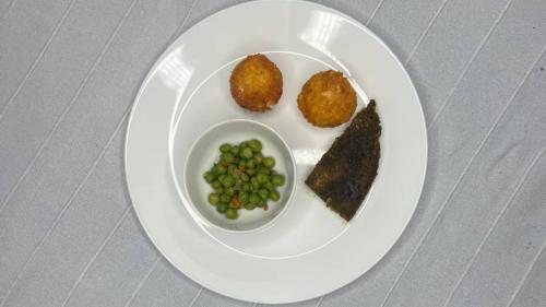 Piatto con piselli, patate e sformato di verdure servito in un rifugio ad Olmedo