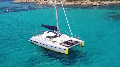 Catamaran with people on board in the crystal-clear waters of the Gulf of Olbia