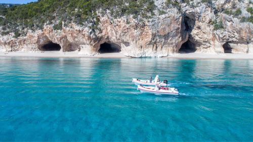 Gommoni navigano a Cala Luna di fronte alle Grotte del Bue Marino