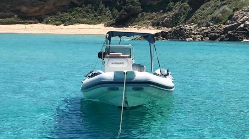 Inflatable boat stops in the blue water of the southern coast of Corsica