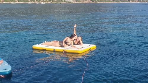 Two people lying on the inflatable island in the sea of the Gulf of Alghero