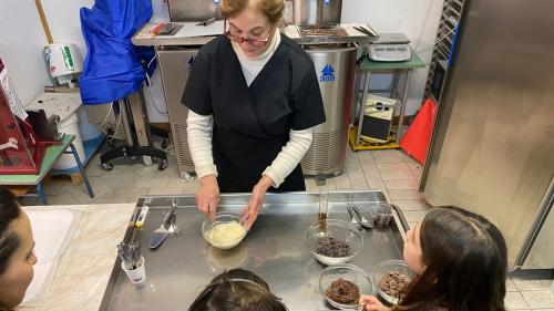 Un guía con excursionistas adultos y niños explica la producción de chocolate