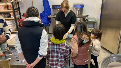 Orientación con niños y adultos durante la explicación de una empresa de producción de chocolate en Laconi